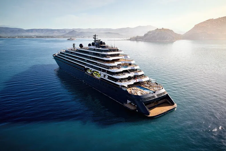 Evrima von The Ritz-Carlton Yacht Collection vor einer bergigen Küste